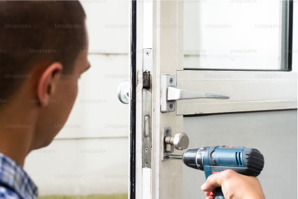 image d'un ouvrier abram's père et fils qui fixe une serrure sur sa porte